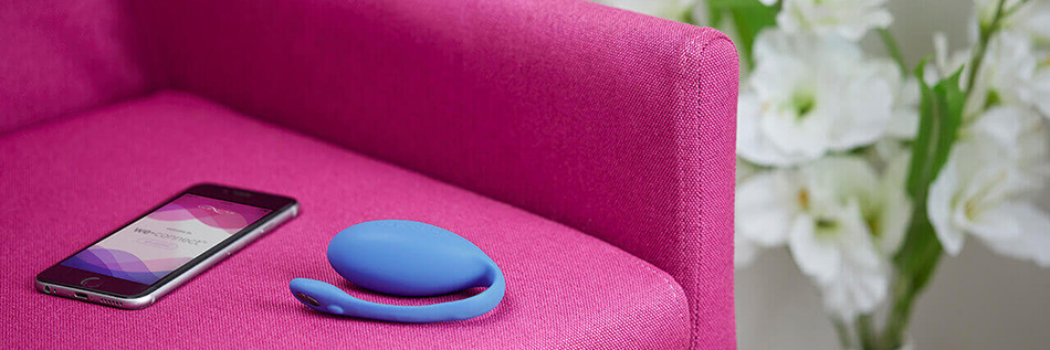 We-Vibe Jive vibrator on pink couch next to iphone with mobile app open