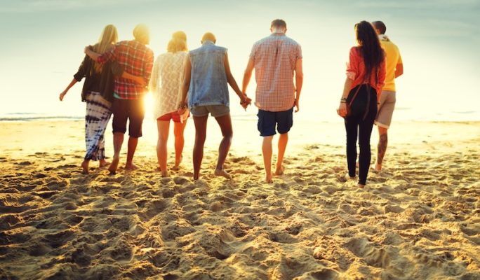 group of friends standing together on the beach