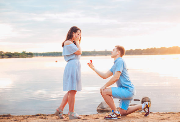 man proposing to woman next to a lake
